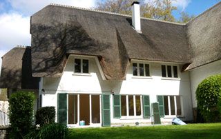 maison blanche avec toit de chaume